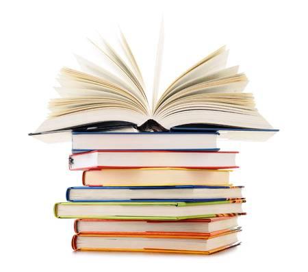 Nell’immagine c’è una pila di libri con sopra un libro aperto