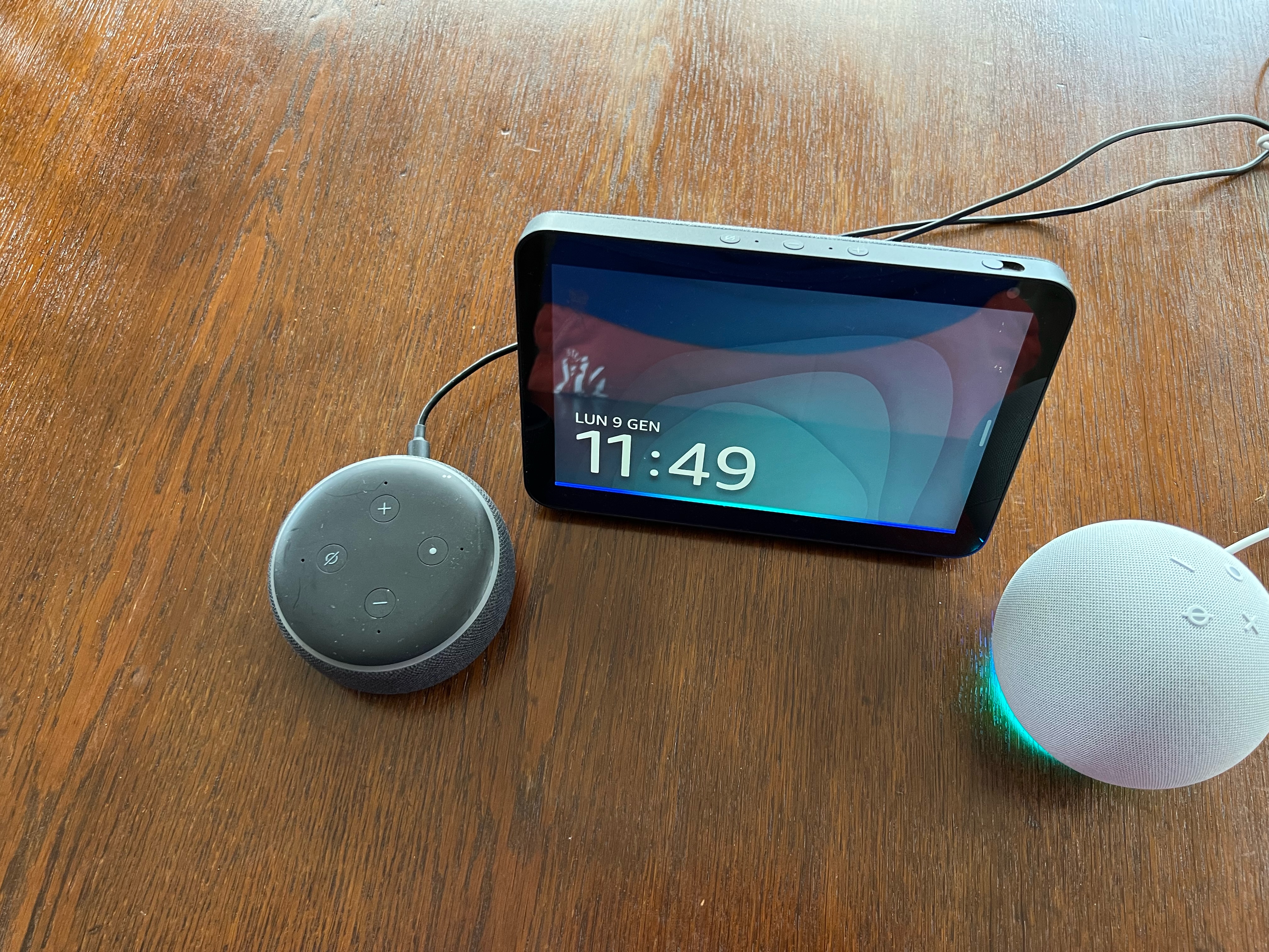 Nell'immagine tre dispositivi Amazon della serie Echo: a sinistra un Echo dot di terza generazione, al centro un Echo Show 5, a destra un Echo Dot di quinta generazione.